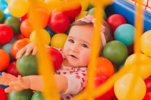 Toddler playing in indoor ball pit at a family-friendly play attraction